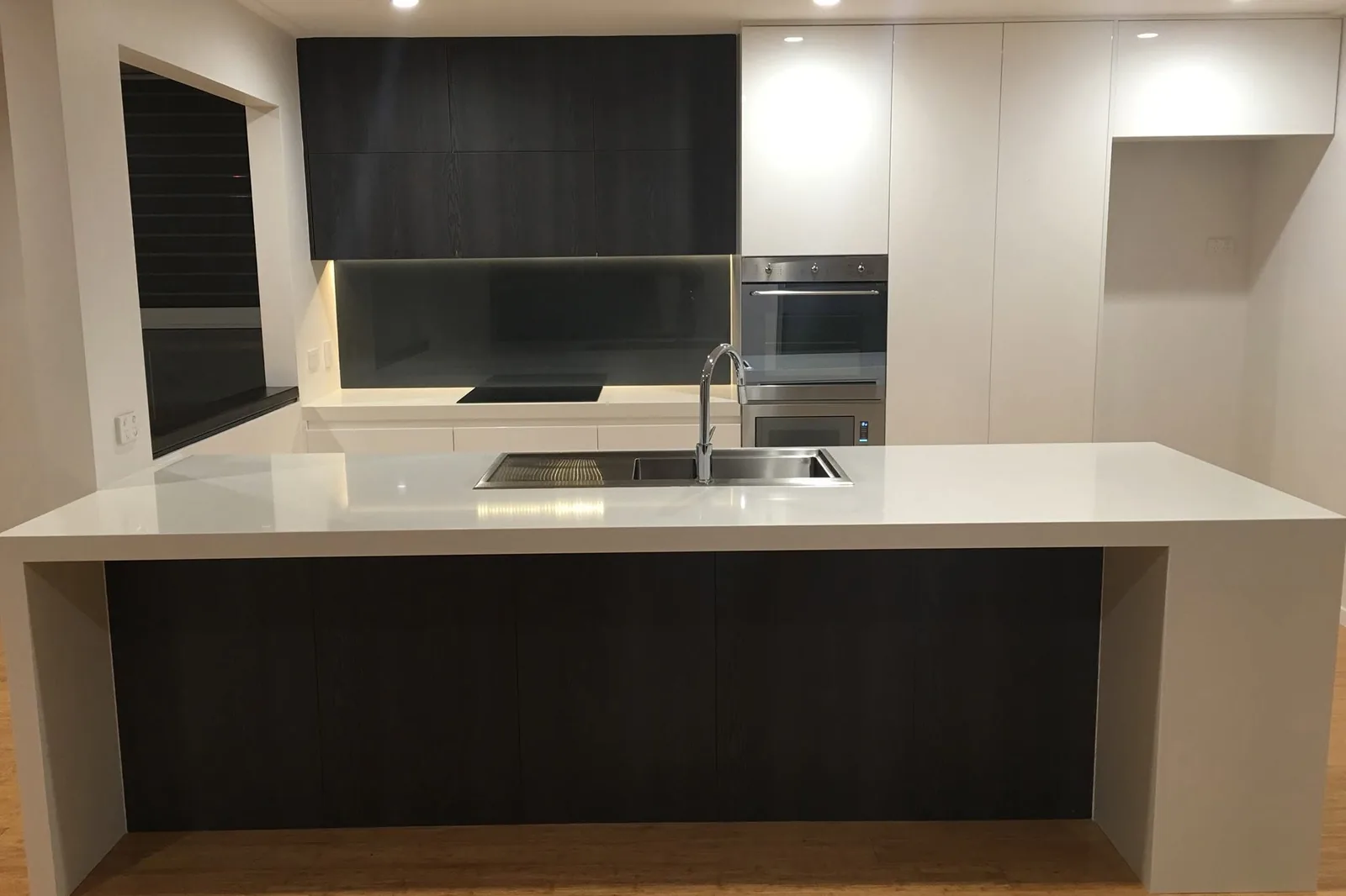 A new kitchen with a stone island bench after the builders clean