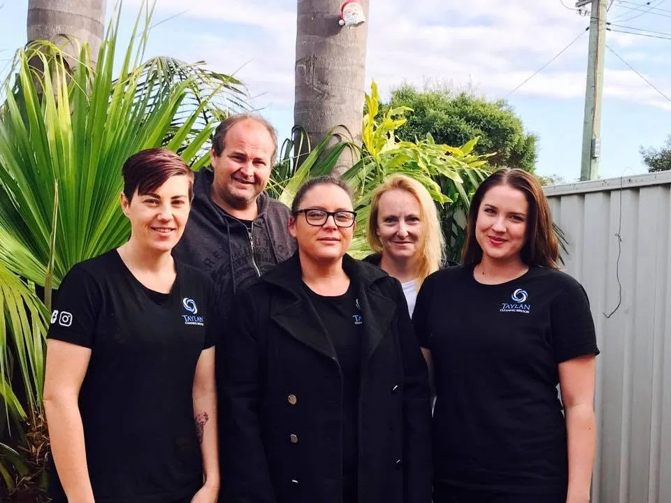 Five members of the Taylan Cleaning crew in their black work shirts