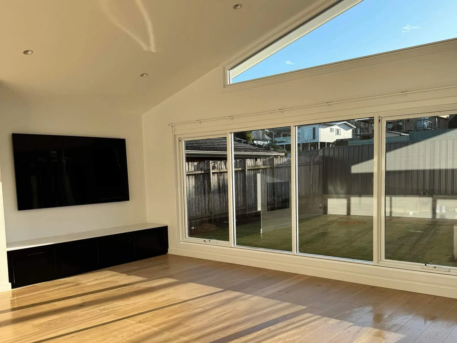 An empty room with polished timber floors and clean glass doors after an end of lease clean