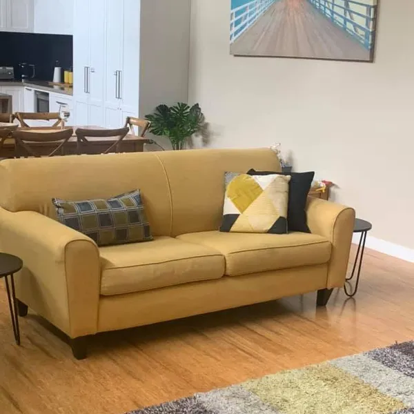 A yellow sofa in a bright holiday rental lounge