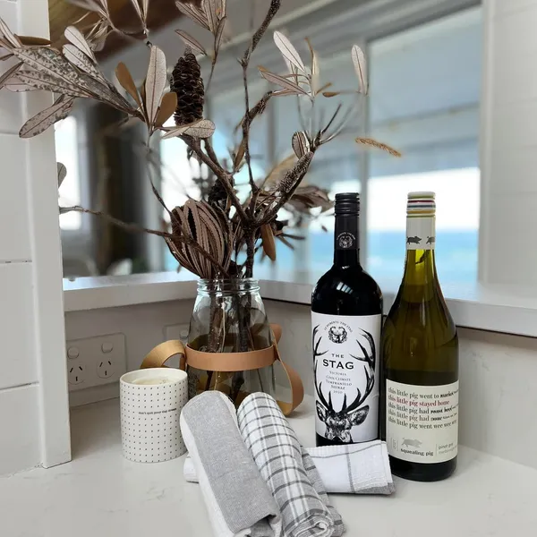 A welcome tray of wine, glasses and folded tea towels on the kitchen bench