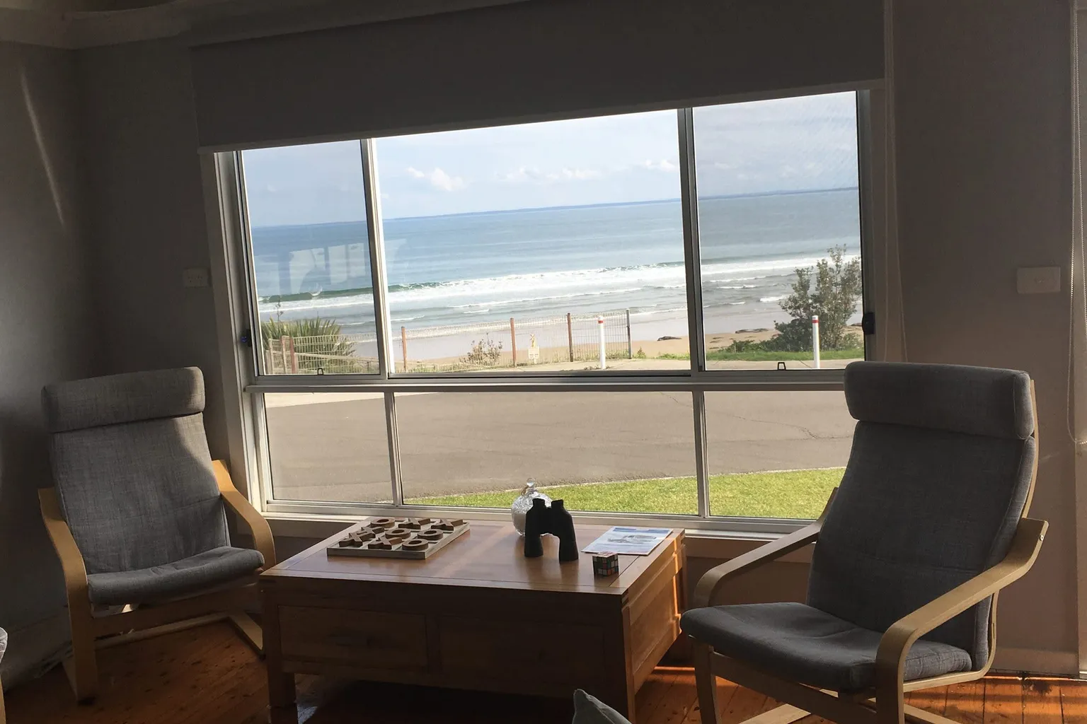 Two armchairs facing the beach through a wide window