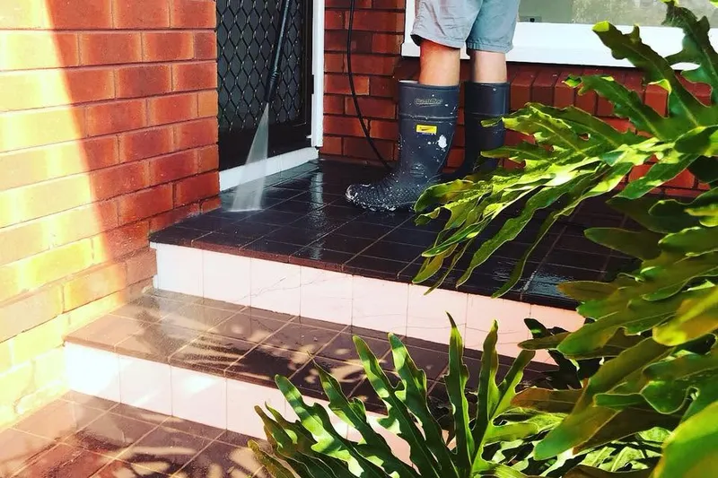 Tiled front steps half pressure washed, the clean half bright beside the dirty half