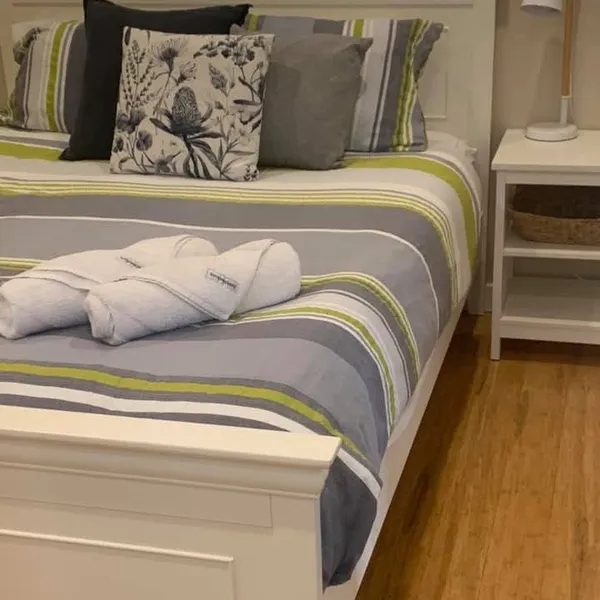 A made bed with folded towels in a holiday rental
