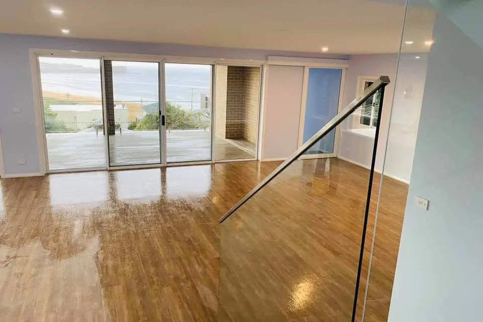 A glass balustrade and sliding doors onto a deck, freshly cleaned